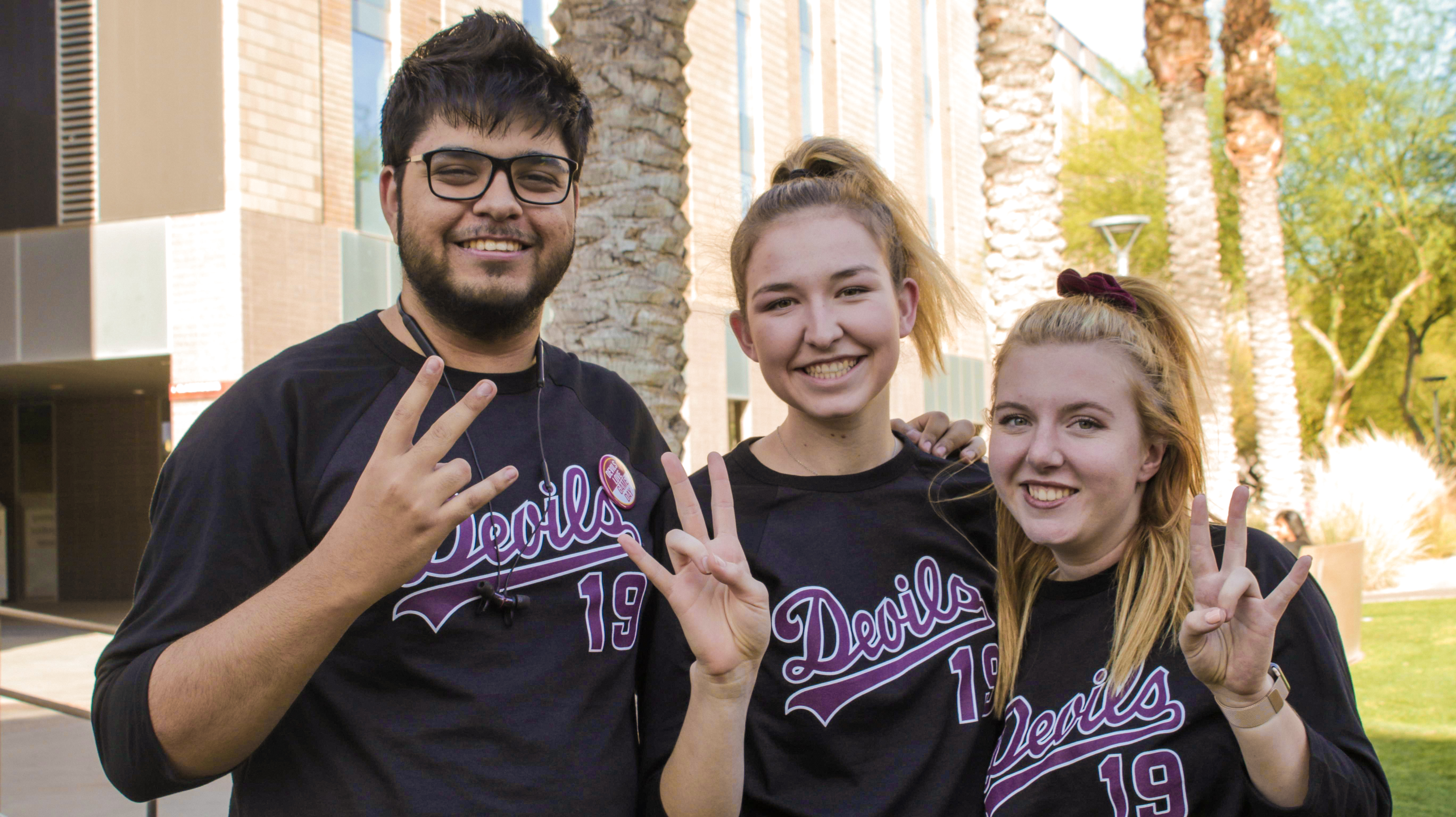 ASU students in baseball jerseys giving a forks up sign before the U of A games