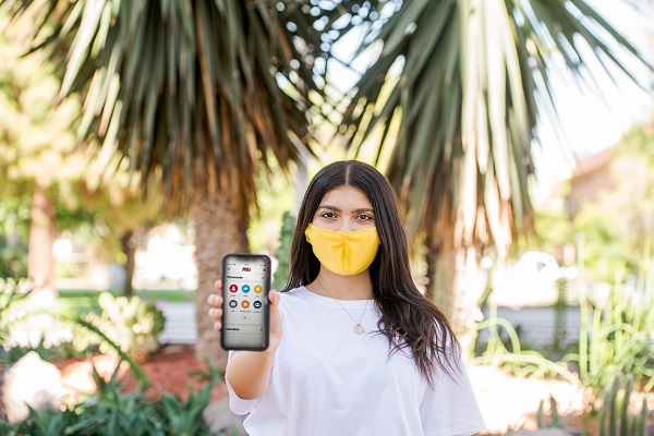 Woman with a cell phone in a mask at an ASU campus
