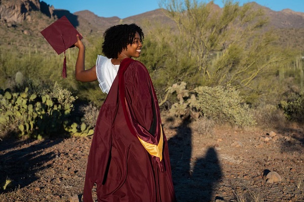  with her cap and gown in a desert landscape