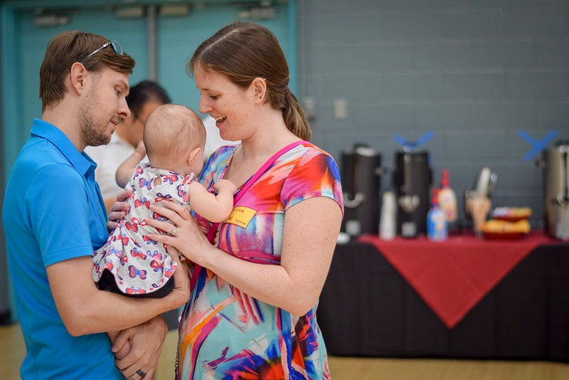 ASU student Olivia Rines holds her infant baby with her husband