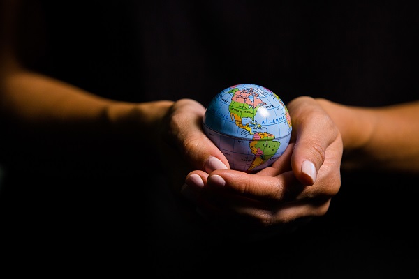 Two hands holding a globe