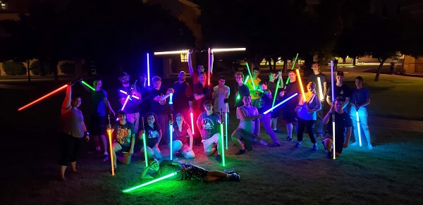 A group of ASU students with lit-up lightsabers at night