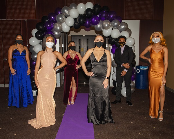 Students in gowns and suits with masks on at the Black Excellence Ball at ASU Tempe