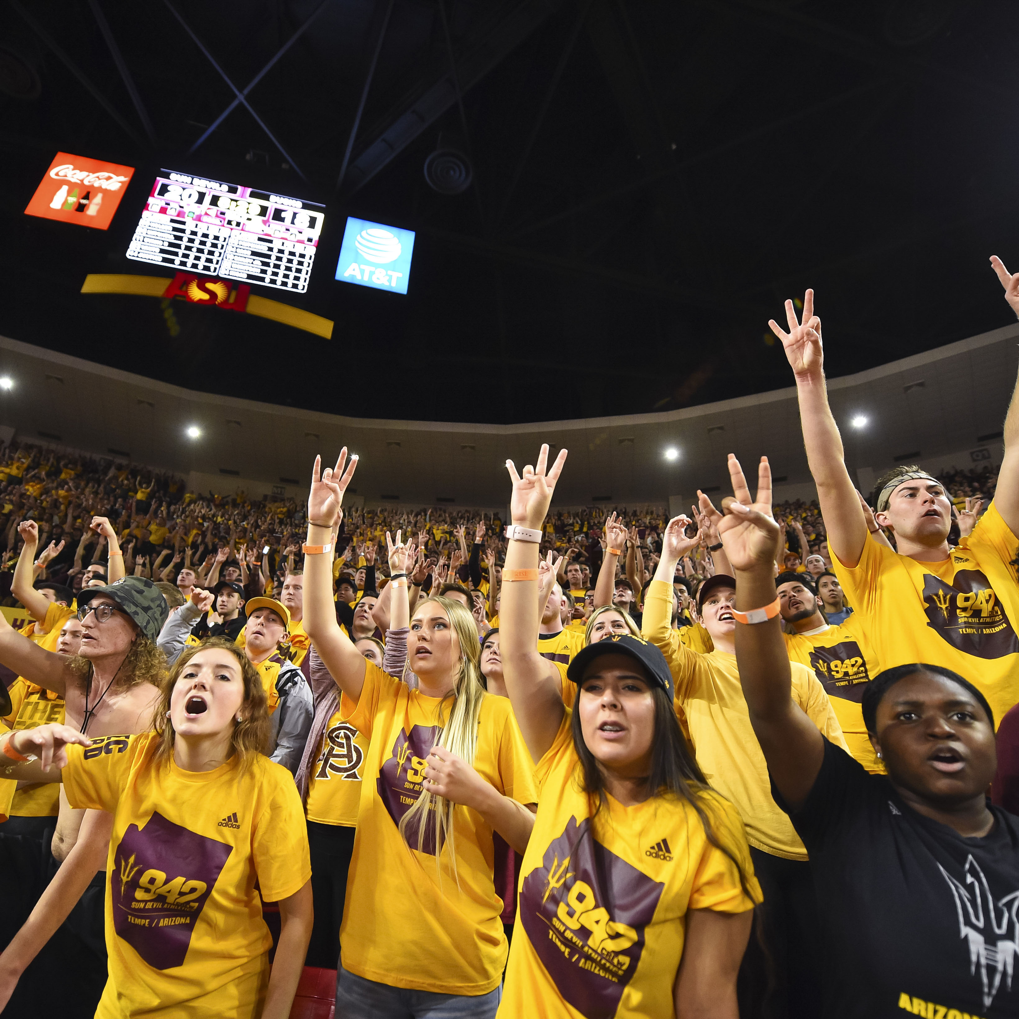 Students give the forks up sign at a basketball game at Wells Fargo Arena