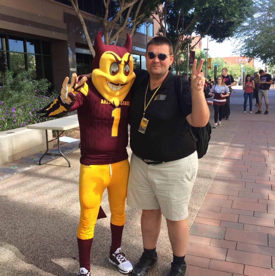 ASU grad James Deibler poses with Sparky at the downtown campus. 