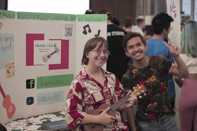 Two students in the Ukulele Club at ASU pose with the forks up hand symbol at Passport to ASU club fair fall 2019
