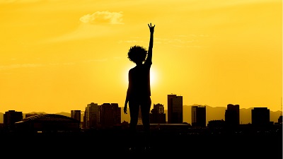 Silhouette of a person giving a forks up at sunset