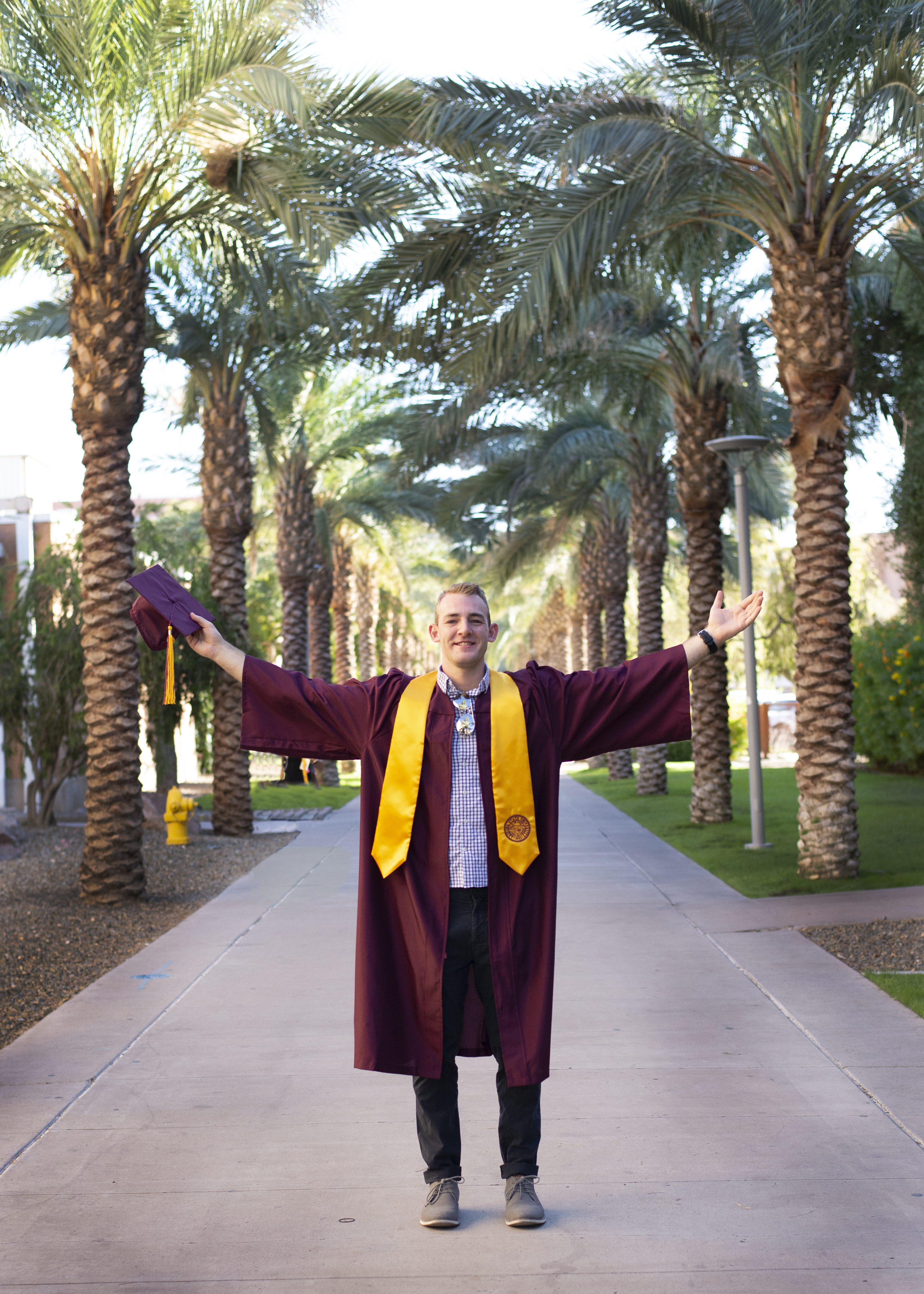  in his cap and gown on Palm Walk at ASU Tempe