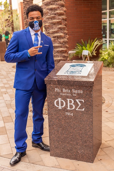 ASU student Style Ranger in a blue suit and mask next to the Phi Beta Sigma NPHC Plot