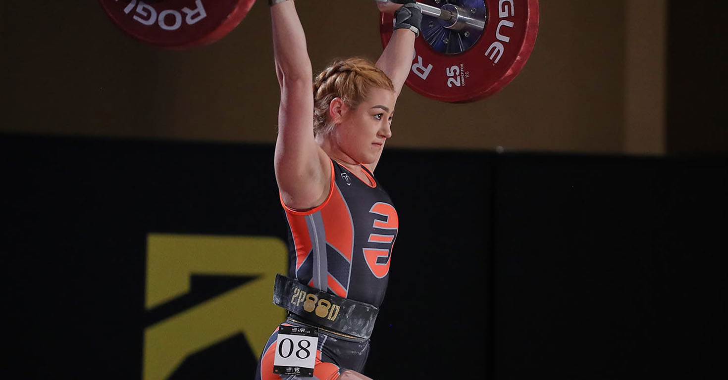 ASU student Yuliana Lopez lifts a large barbell above her head at a competition